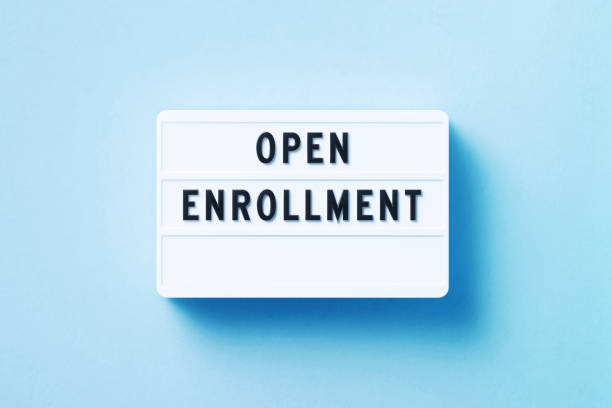 open enrollment scritto white lightbox seduto su sfondo blu - iscrizione foto e immagini stock
