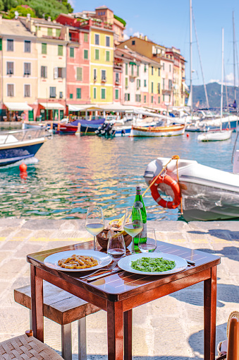 A typical ligurian lunch, gnocchi alla portogino and trofie al pesto, served with white wine on the port of Portofino
