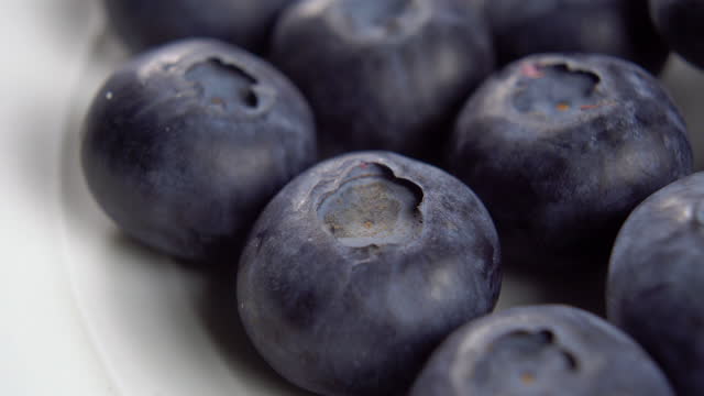Fresh blueberries on a white plate surface close-up. Macro