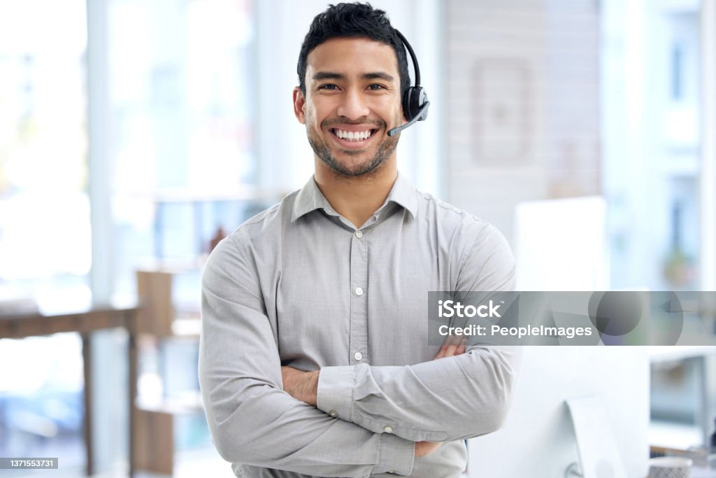 Portrait of a young businessman using a headset in a modern office Give me any query and I'll get it fixed Customer Service Representative Stock Photo