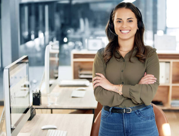 portrait of a young businesswoman using a headset in a modern office - women customer service representative service standing imagens e fotografias de stock