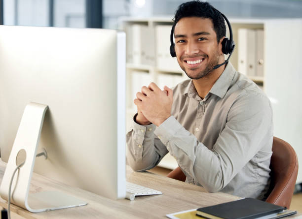 istock Portrait of a young businessman using a headset and computer in a modern office 1371553877