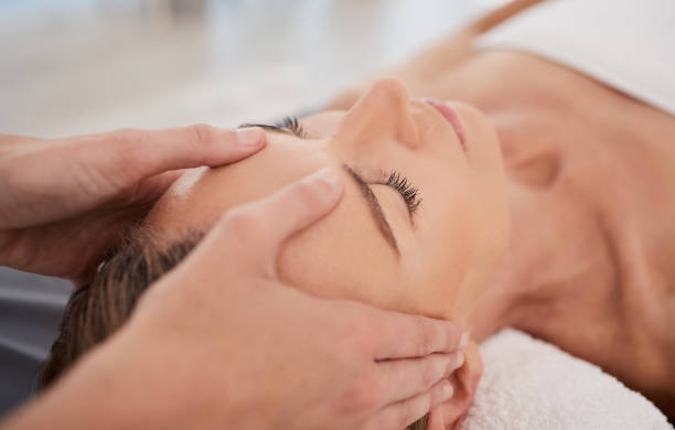 zbliżenie dojrzałej kobiety korzystającej z relaksującego masażu głowy w spa - head massage zdjęcia i obrazy z banku zdjęć