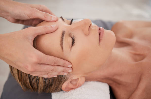 closeup shot of a mature woman enjoying a relaxing head massage at a spa - ogen dicht closeup vrouw 50 jaar stockfoto's en -beelden