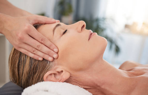 primer plano de una mujer madura disfrutando de un relajante masaje de cabeza en un spa - head massage massaging facial massage beautician fotografías e imágenes de stock