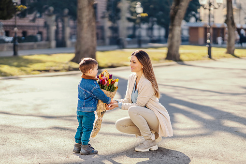 A son giving flowers as a gift to mother on mother's day.