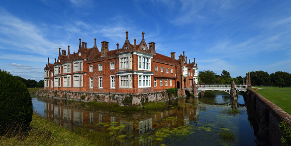 Helmingham, Suffolk, England - August 22, 2019:  Helmingham Hall with moat bridges and reflections.