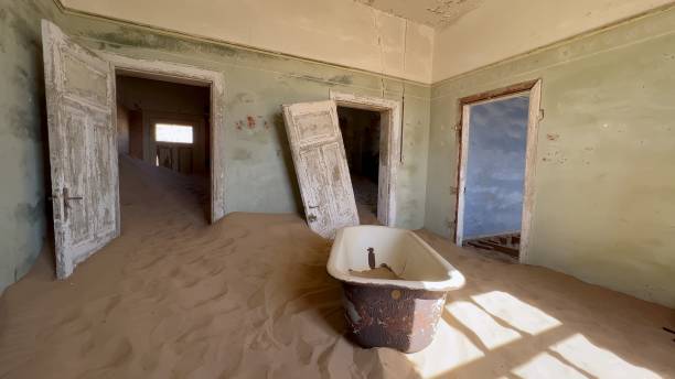 Abandoned building with bathroom and bath tub. Ghost town Kolmanskop in desert Abandoned building with bathroom and bath tub. Ghost town Kolmanskop in the desert. The room is filled with sand inside. Old rusty bathtub in ruined house. kolmanskop namibia stock pictures, royalty-free photos & images