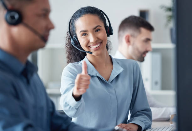 istock Portrait of a young call centre agent showing thumbs up while working alongside her colleagues in an office 1371565457