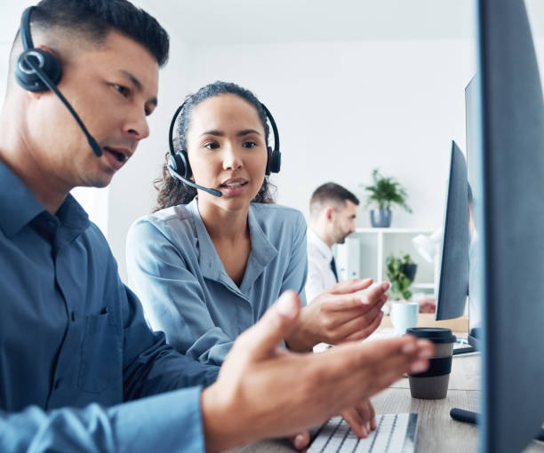 istock Shot of two call centre agents working together on a computer in an office 1371565458