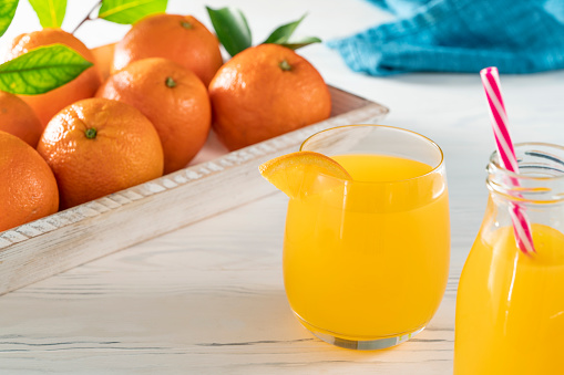 Orange juice homemade on white wooden table background with orange fruits freshly harvested