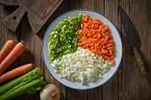 raw ingredients for vegan stir-fry vegetables as chopped Onion and Carrots and minced Celery