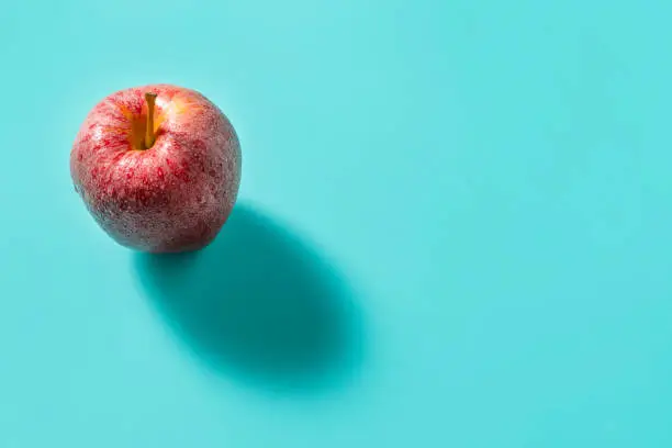 Red apple Royal Gala with shadow isolated on turquoise background with shadow leaving copy space