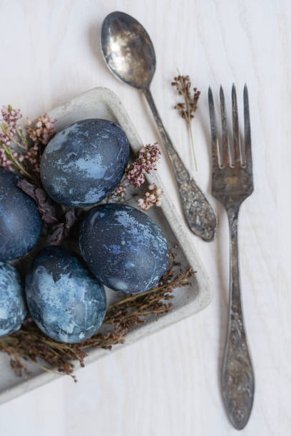 istock blue easter eggs top view, easter eggs on white wooden table with dry flowers and vintage fork and spoon 1371573912