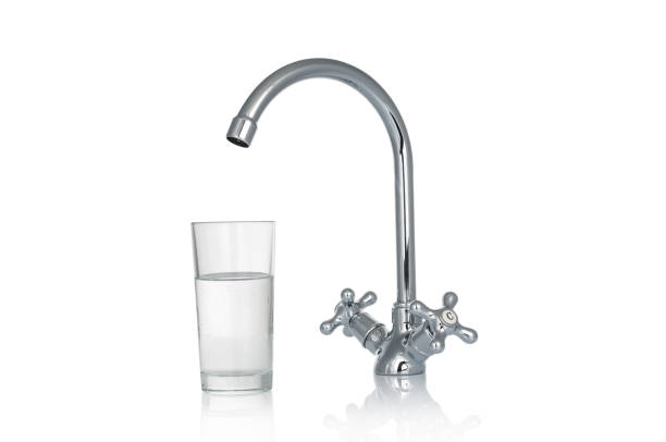 istock Faucet and water glass isolated on white background 1371575593