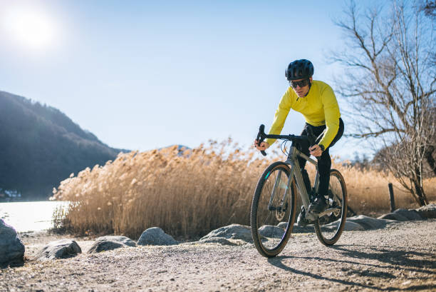 rennradfahrer fährt am sonnigen luganersee vorbei - racing bicycle cycling professional sport bicycle stock-fotos und bilder