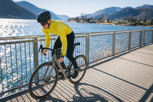 道路自転車は日当たりの良い湖ルガーノを過ぎて乗ります - racing bicycle bicycle cycling yellow ストックフォトと画像
