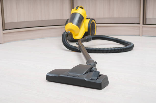 istock Yellow vacuum cleaner with sweeping brush on a wooden floor. Front focus 1371577450