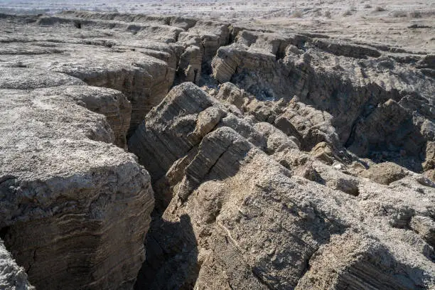 The striated ground collapses to create a sinkhole near the dead sea, Israel.