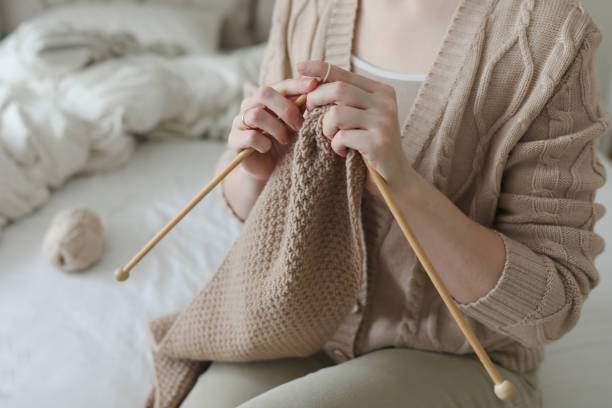 istock Women's hands knitting from woolen beige yarn. 1371582048