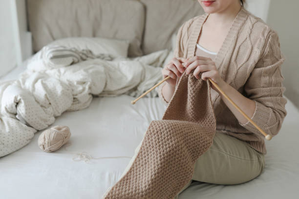 istock Women's hands knitting from woolen beige yarn. 1371583002