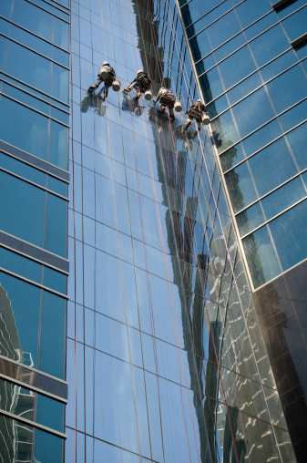 Four window washers on a skyscraper