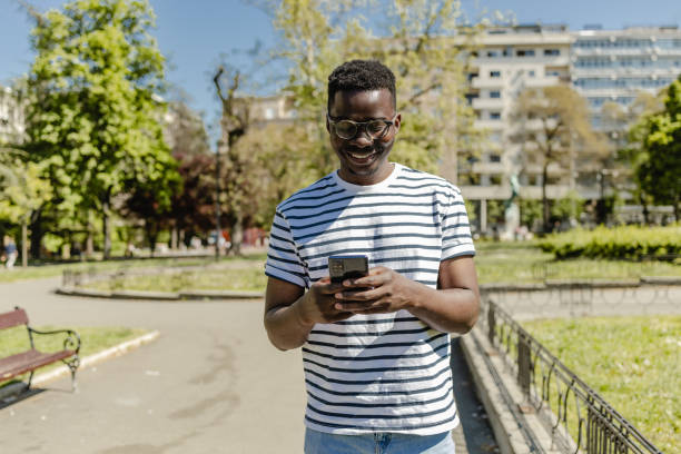 istock African-American young man is using mobile phone in the park 1371586969