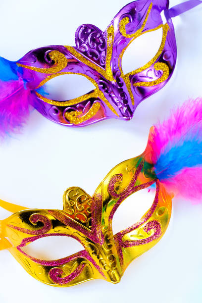 istock Two carnival masks with feathers and multi-colored beads on white background. Mardi Gras or Fat Tuesday symbol. 1371587015