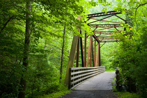 On old railway bed in southwest Virginia has been transformed into a biking path through beautiful Appalachian scenery.  Here a new wooden bridge was built inside the frame of an old railroad trussel. 