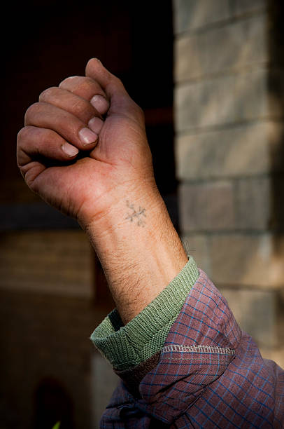 Coptic cross tattoo on wrist of Egyptian Christian man A Coptic Christian in Egypt shows the cross tattoo on his wrist; almost all of Egypt's several million Christians have this tattoo. wrist tattoo stock pictures, royalty-free photos & images