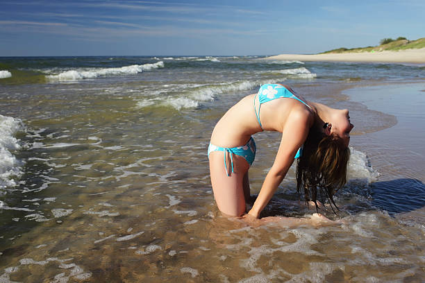 girl on the beach near the sea, close-up on the girl’s arm and leg with a place for an inscription