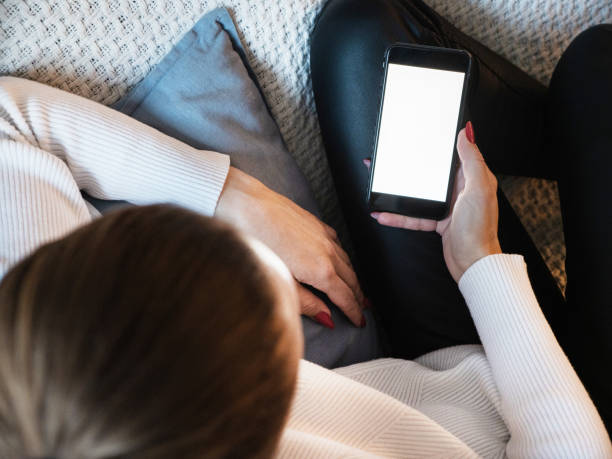 istock Woman using smartphone with blank screen at home 1371600100