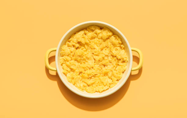istock Scrambled eggs above view minimalist on an orange background 1371601646
