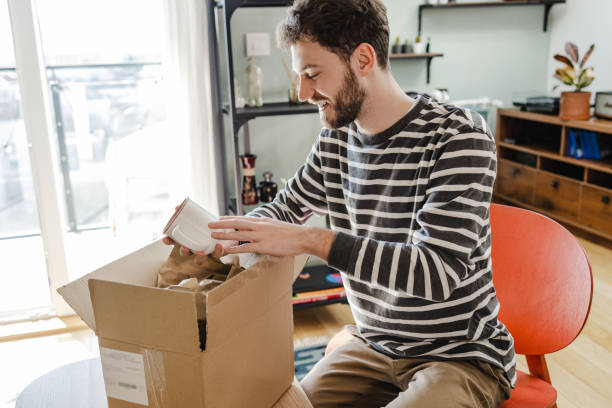 istock Young man unpacks the box with online ordered items 1371603745