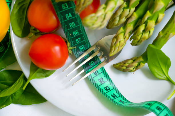 istock fresh vegetables, measuring tape, fork on wooden background 1371603750