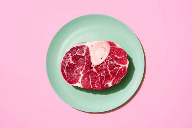 сырой стейк из говядины вид сверху на розовом фоне. - veal raw meat pink стоковые фото и изображения