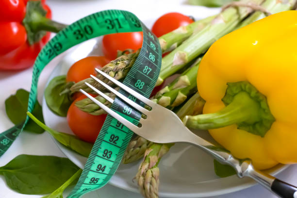 istock fresh vegetables, measuring tape, fork on wooden background 1371604314