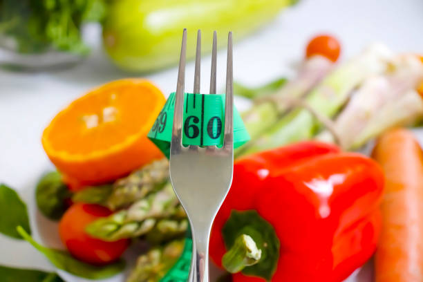 fresh vegetables, measuring tape, fork on wooden background