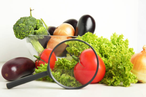 Different fresh vegetables and magnifying glass on table. Poison detection