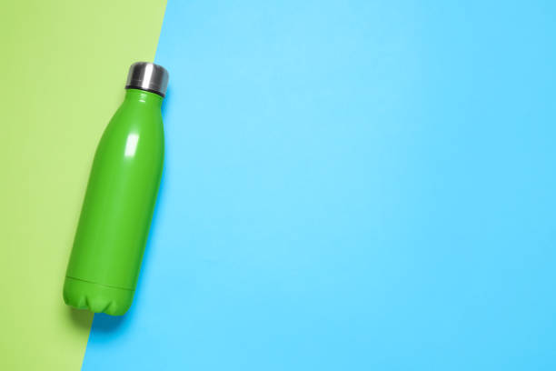 istock Green bottle on color background, top view. Space for text 1371611961
