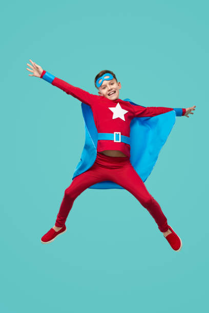 istock Excited superhero boy jumping in studio 1371620630