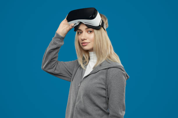 istock Blond female gamer taking off VR goggles 1371620662