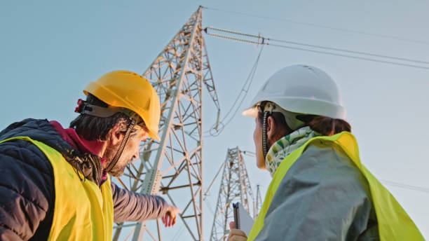 High voltage engineers working on the field. Teamwork. Electrical engineers working on Electrical Pylons Translation, discussing the condition of the Electrical Power Pole. electrical grid stock pictures, royalty-free photos & images