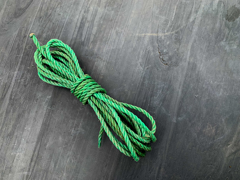 green nylon rope which is usually used to tie the pile of wood scattered behind the house