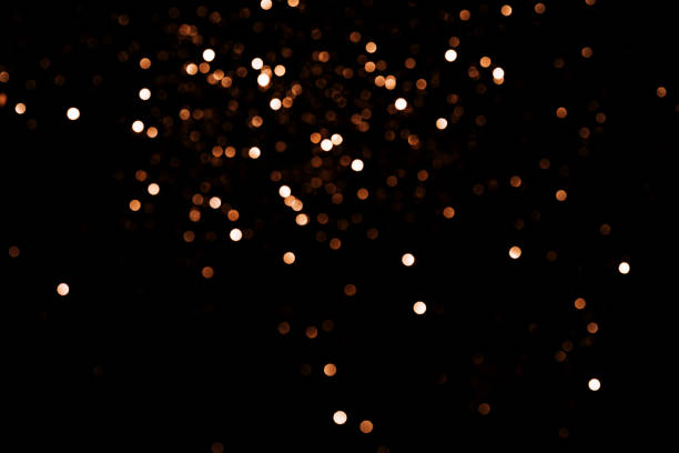 istock Falling gold colored confetti against black background 1371635136