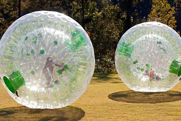 Photo of Kids Rolling Inside Large Plastic Balls