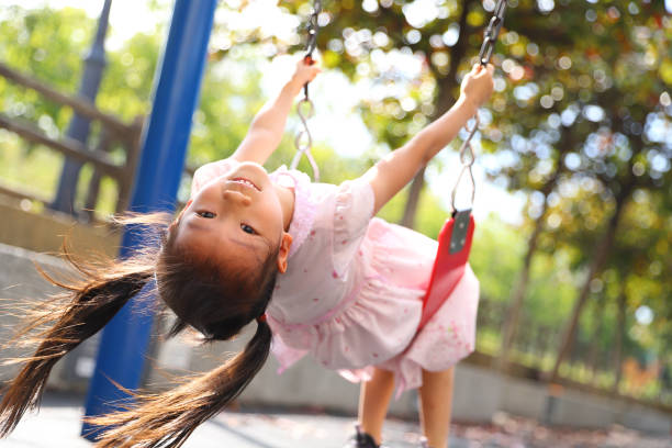 istock girls playing swing. 1371638740