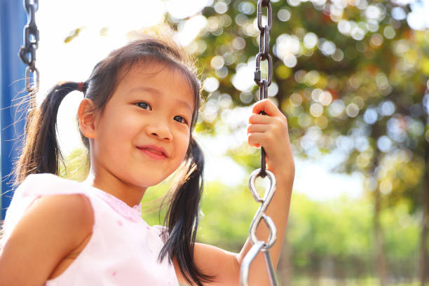 istock girls playing swing. 1371638851