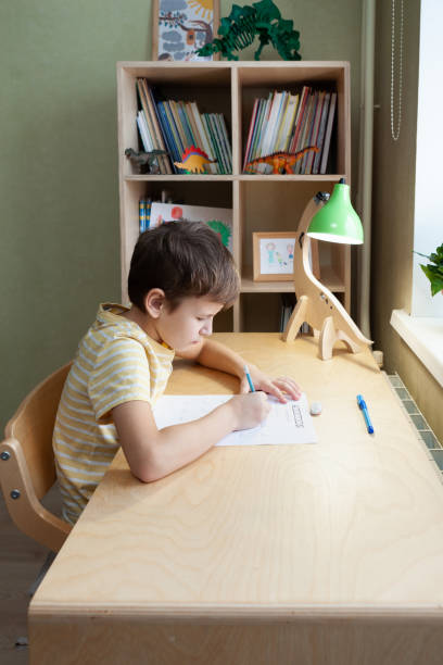 istock A schoolboy doing math lesson sitting at desk in the children room 1371640585