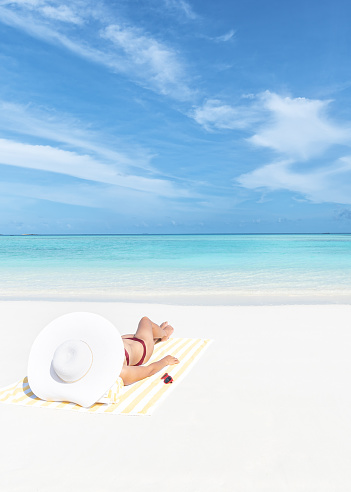 Young attractive woman in bikini sunbathing on the exotic beach